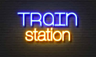 Train station neon sign on brick wall background.