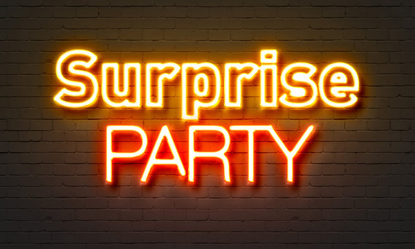 Surprise party neon sign on brick wall background.