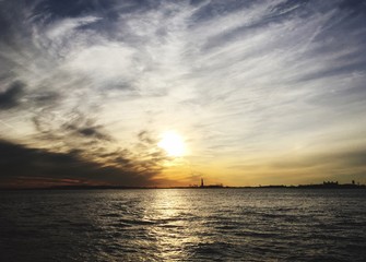 Statue of Liberty on Liberty Island in New York Harbor at Sunset.  Dramatic sky with dynamic clouds...