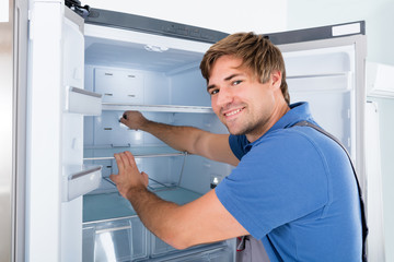 Naklejka na ściany i meble Technician Examining Refrigerator
