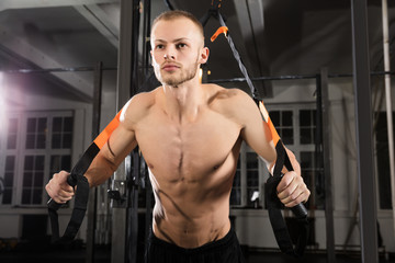 Fototapeta na wymiar Man Exercising With Suspension Trainer