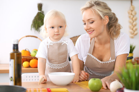 Happy family in the kitchen. Mother and child daughter cooking tasty breakfast