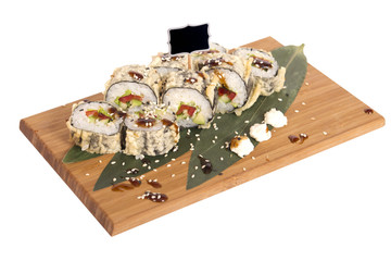 Sushi rolls on wooden Board with leaves of leeks and black sign for logo and name