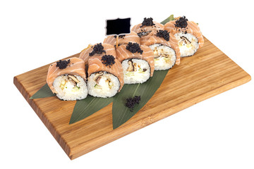 Sushi rolls on wooden Board with leaves of leeks and black sign for logo and name