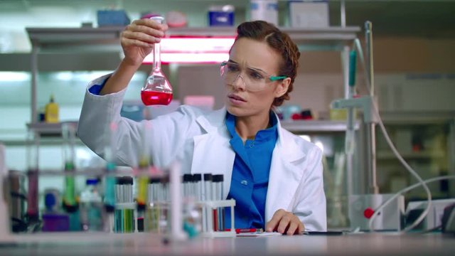 Chemist in lab. Chemical engineering. Female chemist working with chemical liquid in research lab. Woman chemist analyzing chemical reagents in laboratory. Woman scientist conducting chemical research