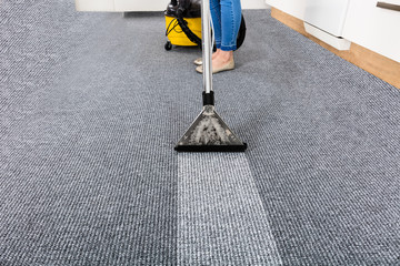 Janitor Cleaning Carpet With Vacuum Cleaner