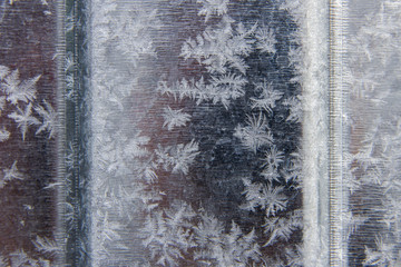 Patterns of natural frost and snowflakes on a metal