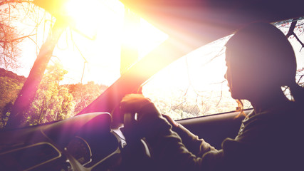 Sun during the day time driving on the road at speed. women driving car