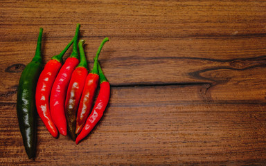 Fresh red hot chili peppers on rustic wood background.