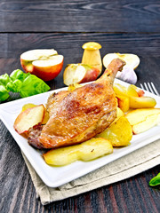 Duck leg with apple and basil in plate on napkin