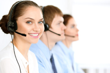 Call center operators. Focus at brunette business woman in headset