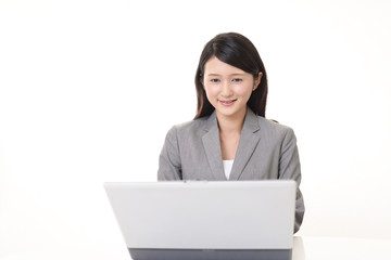 ノートパソコンで仕事中のビジネスウーマン