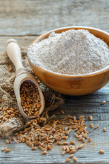 Wheat wholemeal flour in a wooden bowl.