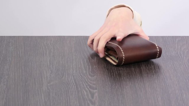 Purse on the table, children's hand stealing wallet. 