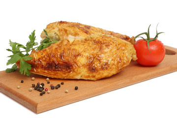 Grilled chicken fillet wit tomato on plate on wood background