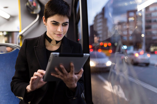 Woman browsing tablet inside the bus