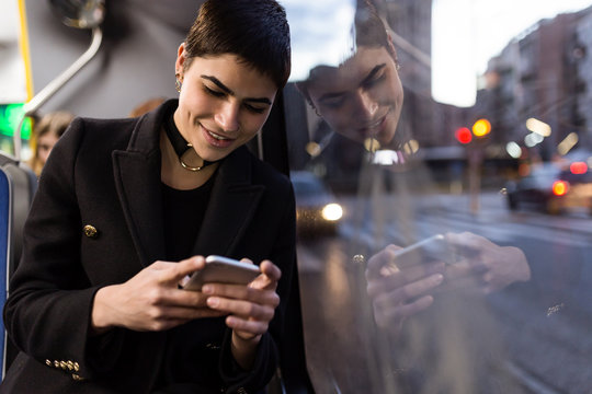 Woman browsing smartphone in the bus