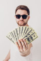 handsome smiling man with beard in shirt holding hundred-dollar 