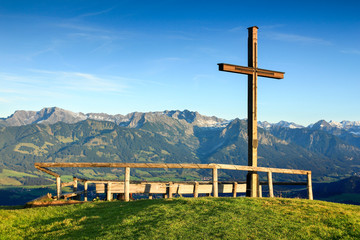 Wooden summit cross with scenic view to mountain range