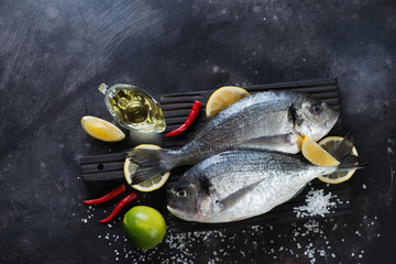Couple of raw fresh sea breams with seasonings, above view