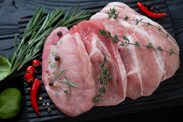 Close-up of fresh uncooked pork loin steaks and condiments