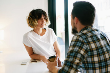 Colleagues are talking about new projects of the company during coffee break. Freelancers are discussing modern trends in a digital marketing. Business people are negotiating at the informal meeting.