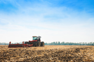Modern tractor in the field with complex for the plowing of soil.