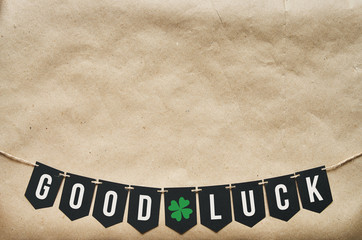 GOOD LUCK garland letters on eco craft paper background. St. Patricks day greeting card, holiday poster, banner, postcard template. Empty space for copy, text, message, lettering, inscription.
