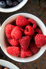 Raspberry in a bowl on a rusty background