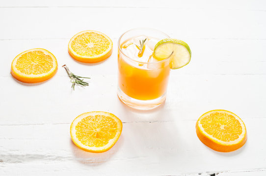 Glass of orange juice on white wooden table
