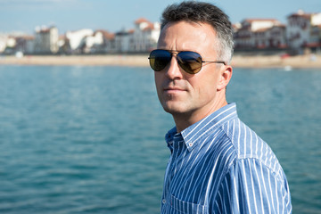 Handsome man. Outdoor male portrait. Middle-aged man resting at seafront, summer outdoor portrait, image toned.