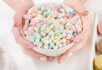 Womans hands with sweet marshmallows