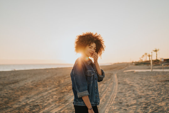 Chica feliz en la playa con el atardecer 