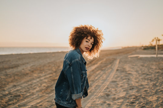Chica feliz en la playa con el atardecer 