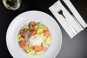 Salad with marinated salmon on a white plate