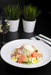 Salad with marinated salmon on a white plate