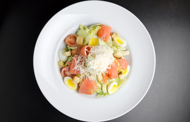 Salad with marinated salmon on a white plate