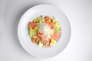 Salad with marinated salmon on a white plate