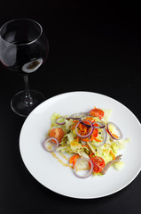Thai salad with beef and vegetables on a white plate on a black table
