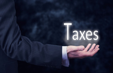 Hand holding a Taxes Concept