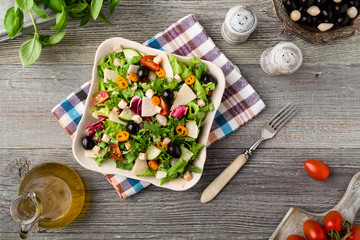 Italian salad with fresh vegetables with black olives and Parmesan cheese.