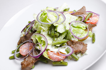 Salad with beef roast beef and vegetables on a white background