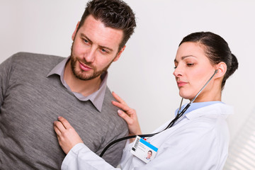 Young female doctor listening to a heartbeat