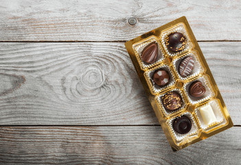 Assorted chocolate candies on a wooden background