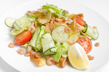 Salad from seafood and vegetables on a white plate