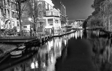 Fototapeta premium AMSTERDAM - MAY 1, 2013: City canals at night for Queen's Day. Amsterdam attracts 10 million visitors every year