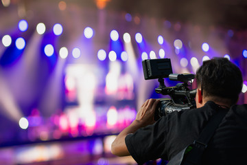 Covering an event on stage with a video camera.