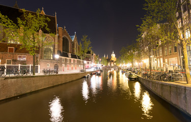 AMSTERDAM - MAY 1, 2013: City canals at night for Queen's Day. Amsterdam attracts 10 million visitors every year