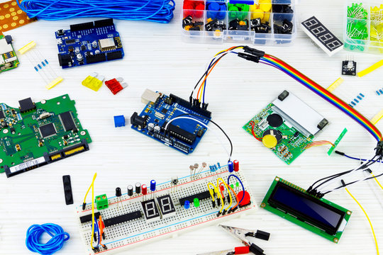 Microcontrollers, chips, resistors and light-emitting diodes on white desktop of hardware engineer