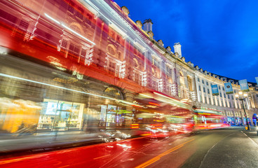 Fototapeta na wymiar LONDON - JUNE 2015: Traffic after sunset in Oxford Street. London attracts 30 million people annually